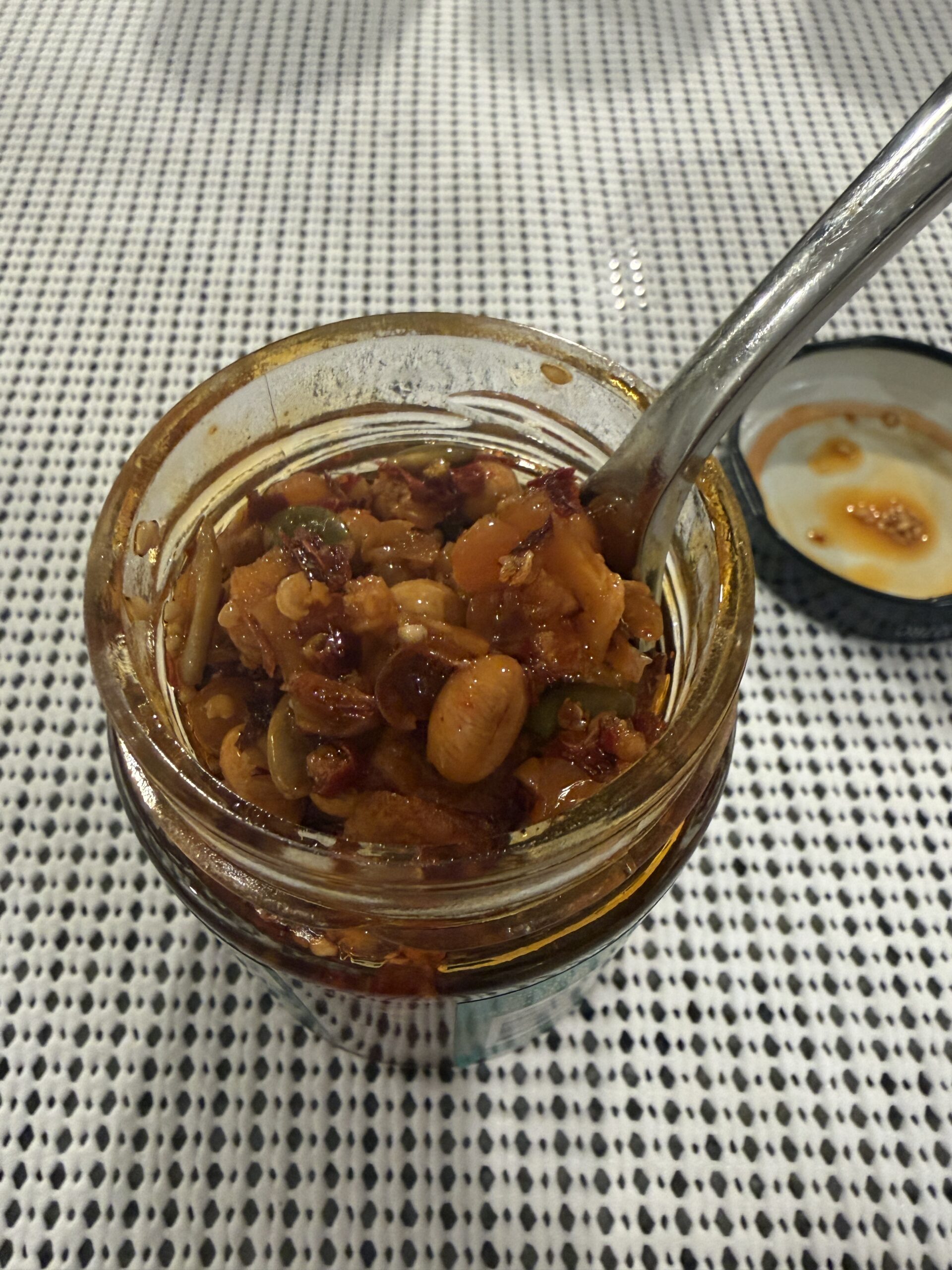 Fly By Jing Xtra Crunchy chili crisp lifted on fork showing seeds and beans — Flavor Index Lab