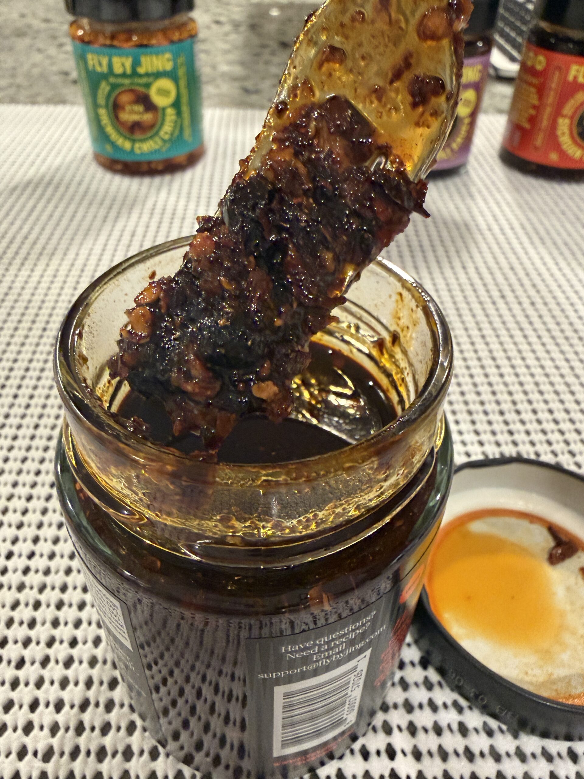 Fly By Jing Xtra Spicy chili crisp on a fork showing oil and chili bits — Flavor Index Lab