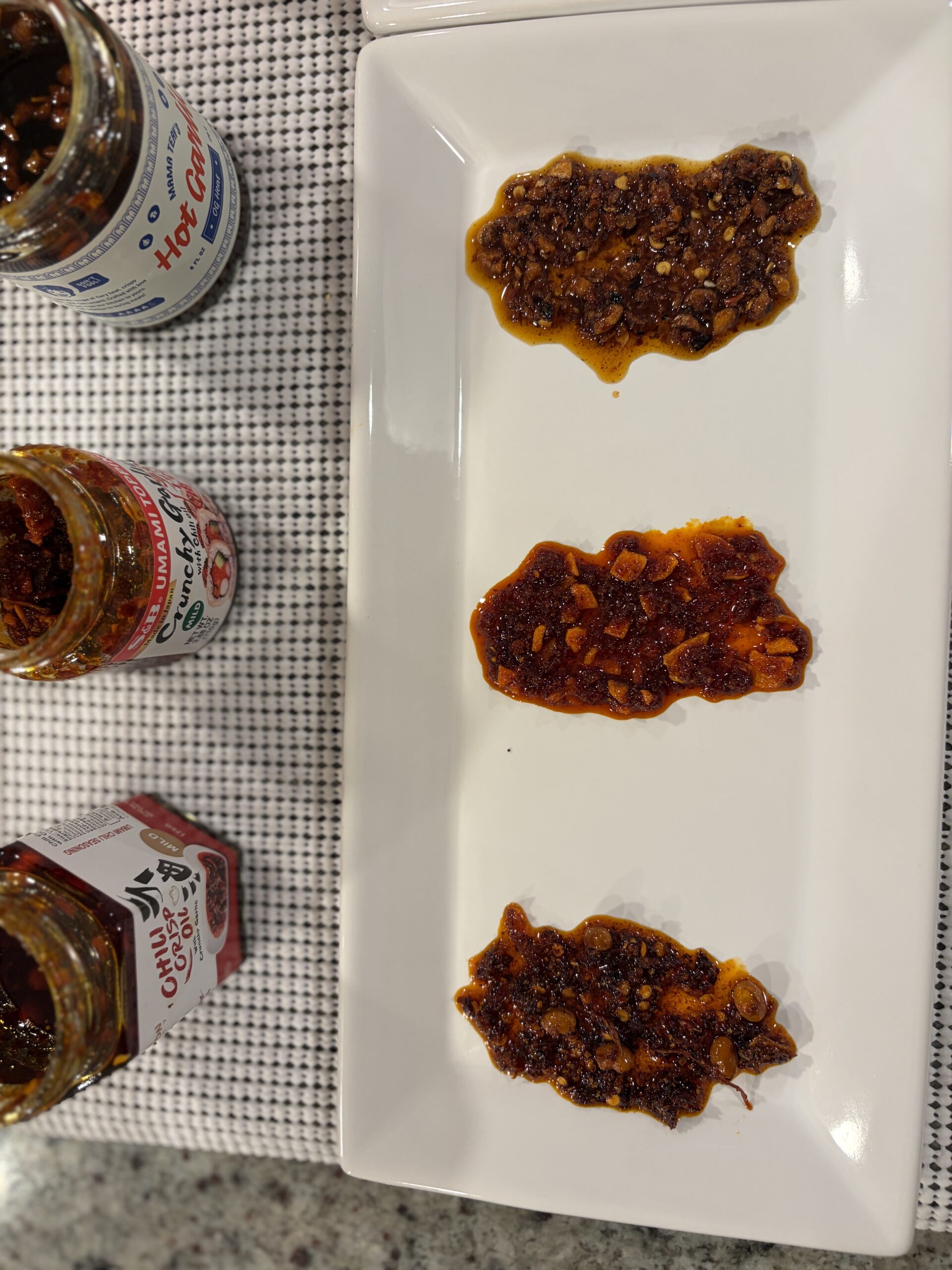Top-down view of S&B, Fusion Select, and Momofuku garlic chili crisps showing bit size and oil clarity — Flavor Index Lab