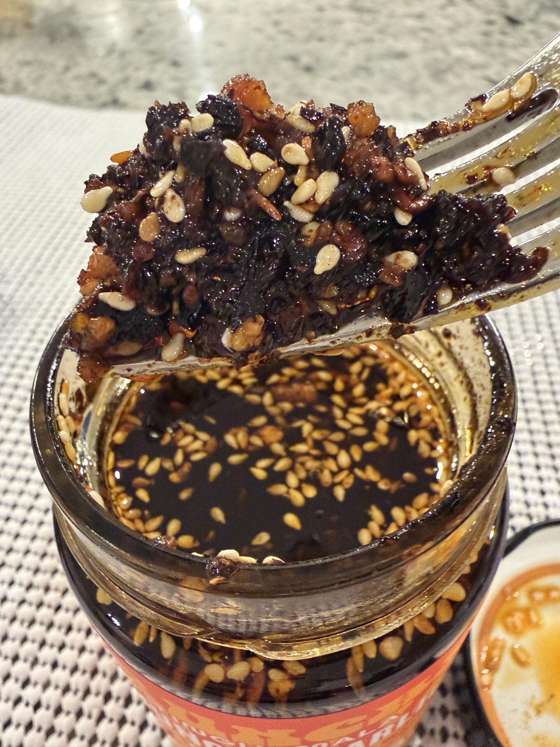 Hotpot Queen chili crisp fork pull showing chewy Sichuan peppercorn solids — Flavor Index Lab