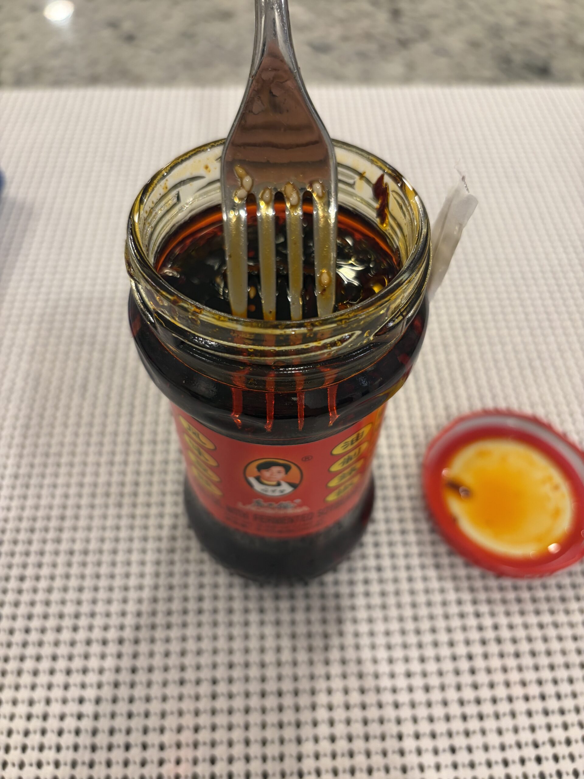 Fork resting on Lao Gan Ma Fermented Soybeans chili oil solids — Flavor Index Lab
