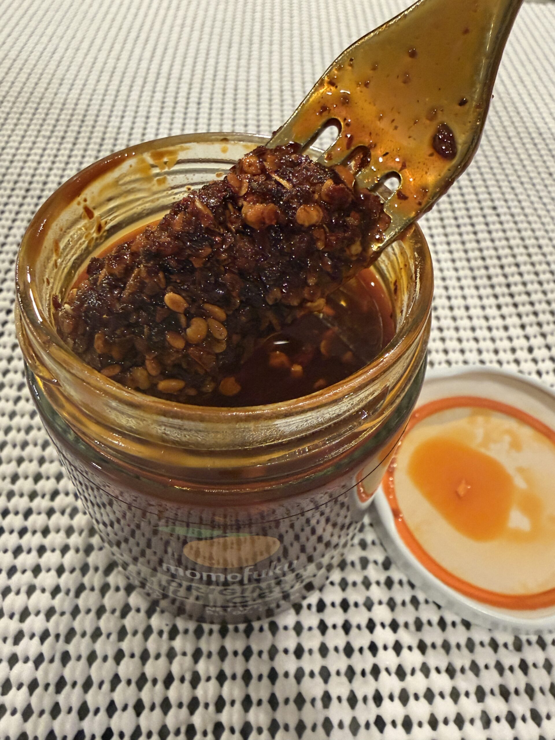Momofuku Chili Crunch thick reddish-brown oil dripping from a fork — Flavor Index Lab