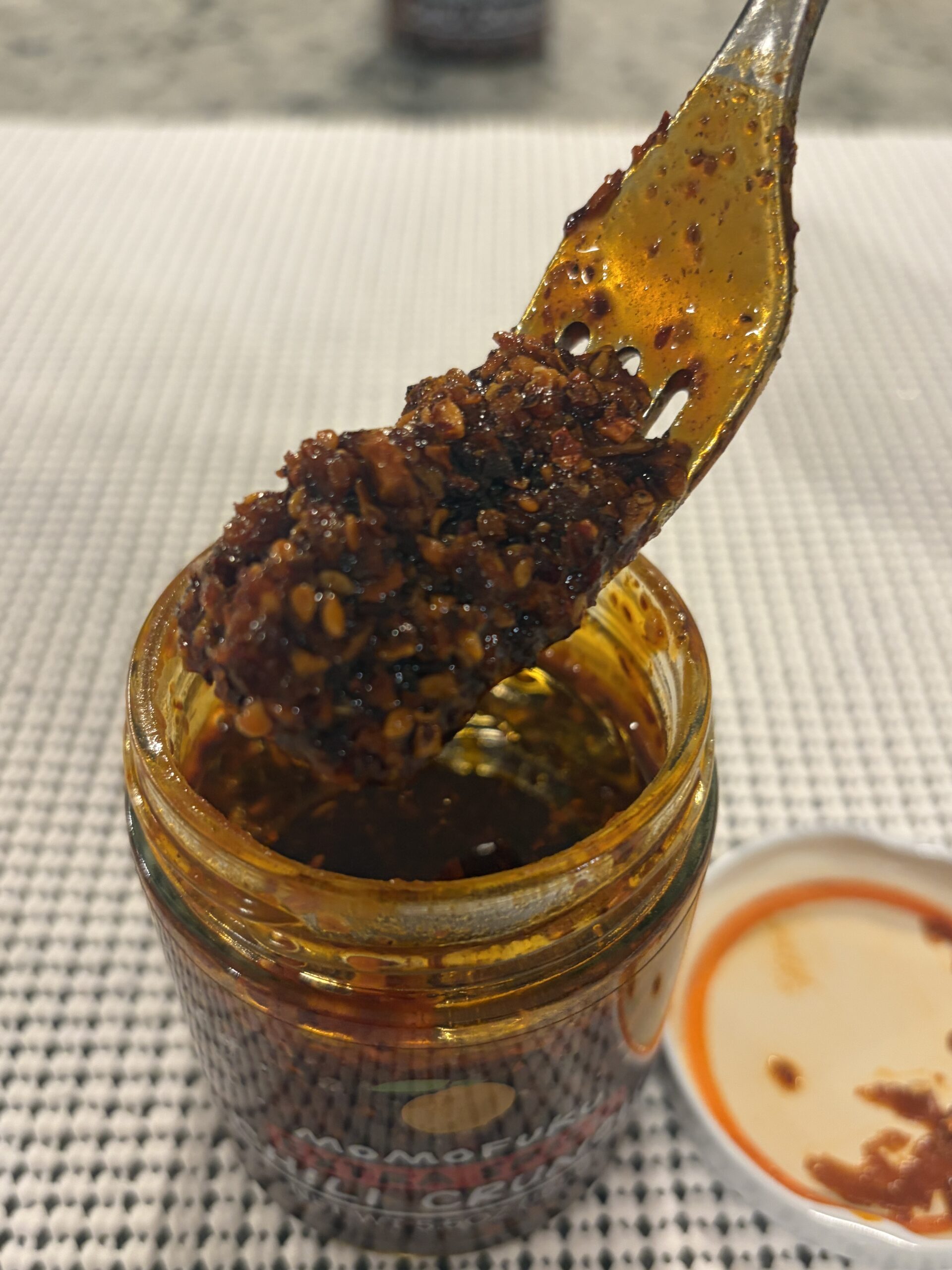 Momofuku Extra Spicy Chili Crunch fork pull showing oil and crispy bits — Flavor Index Lab