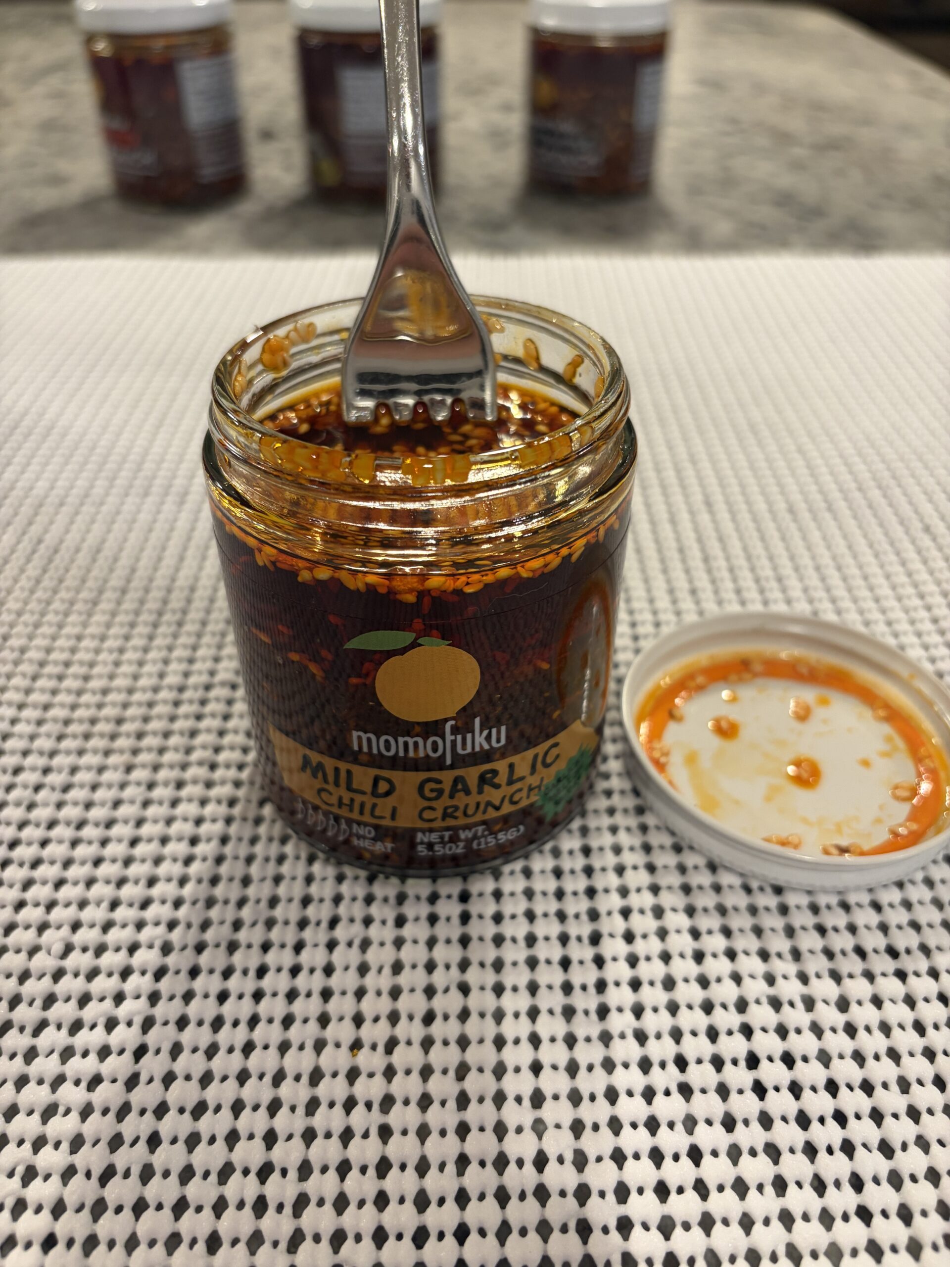 Fork resting on Momofuku Mild Garlic Chili Crunch solids without sinking — Flavor Index Lab