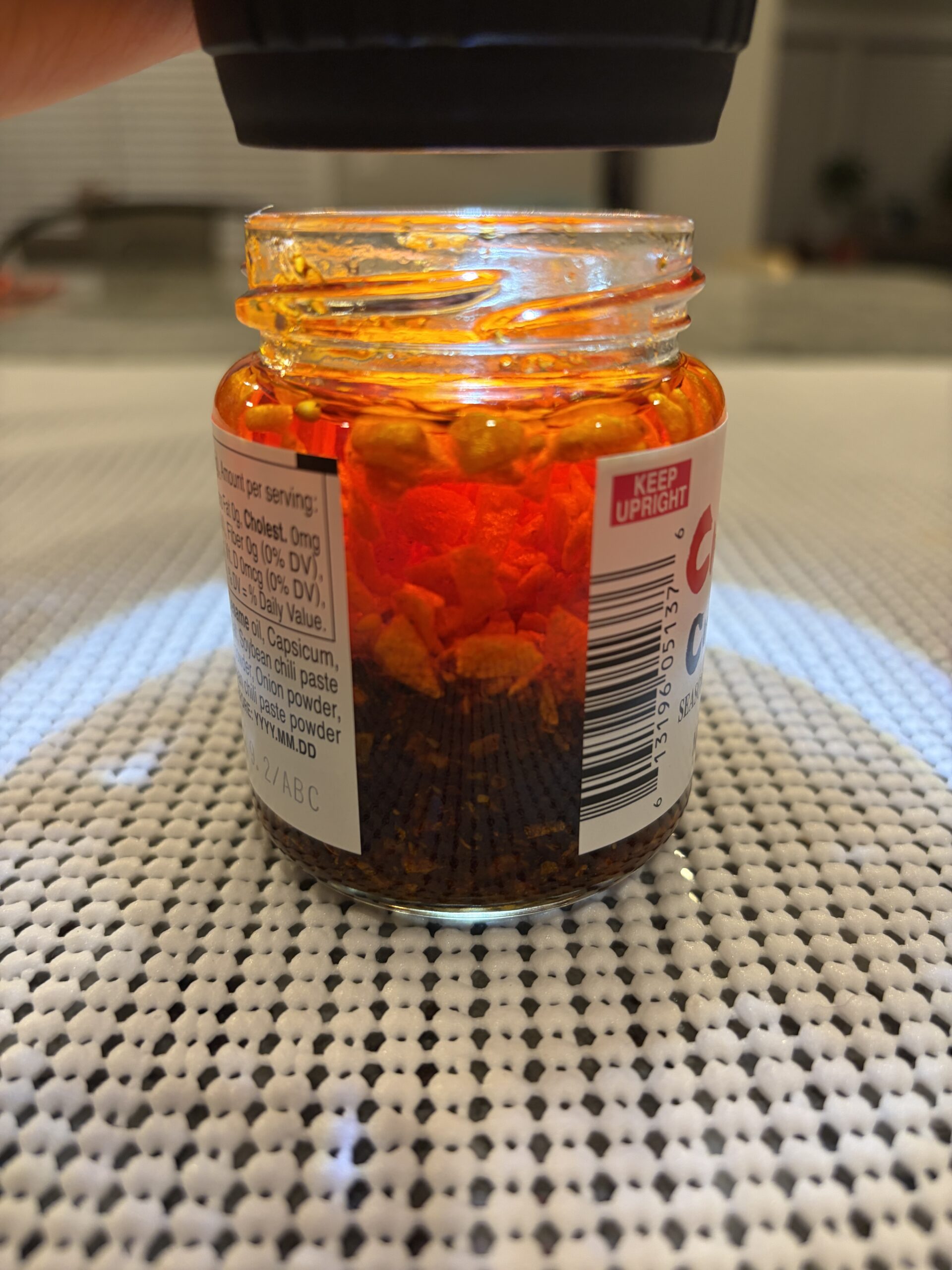 Momoya chili oil settlement showing dense fried garlic solids — Flavor Index Lab