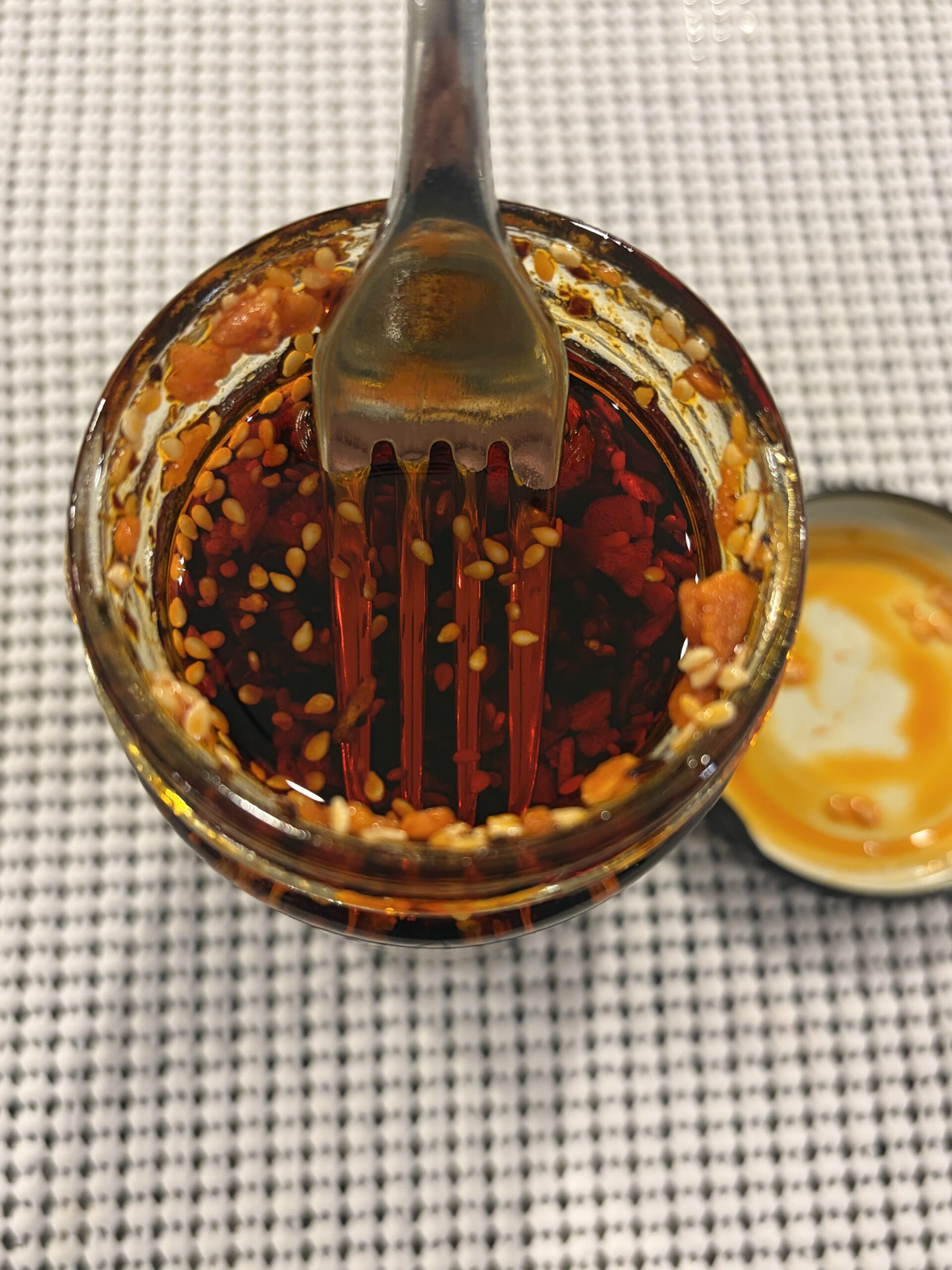 Fork resting on WUJU chili crisp solids without sinking — Flavor Index Lab