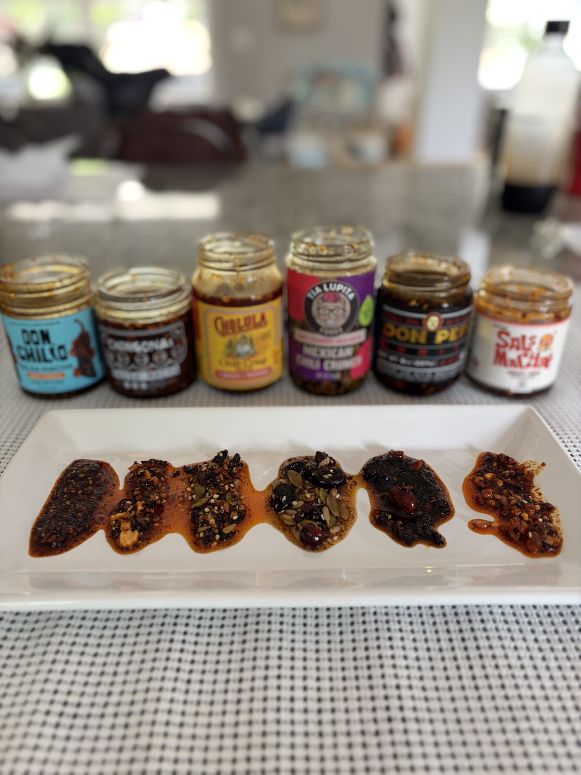 Don Chilio, CHiNGONAs, Cholula, Tia Lupita, Don Pepe, and Sauce Up salsa macha plated for side-by-side tasting — Flavor Index Lab