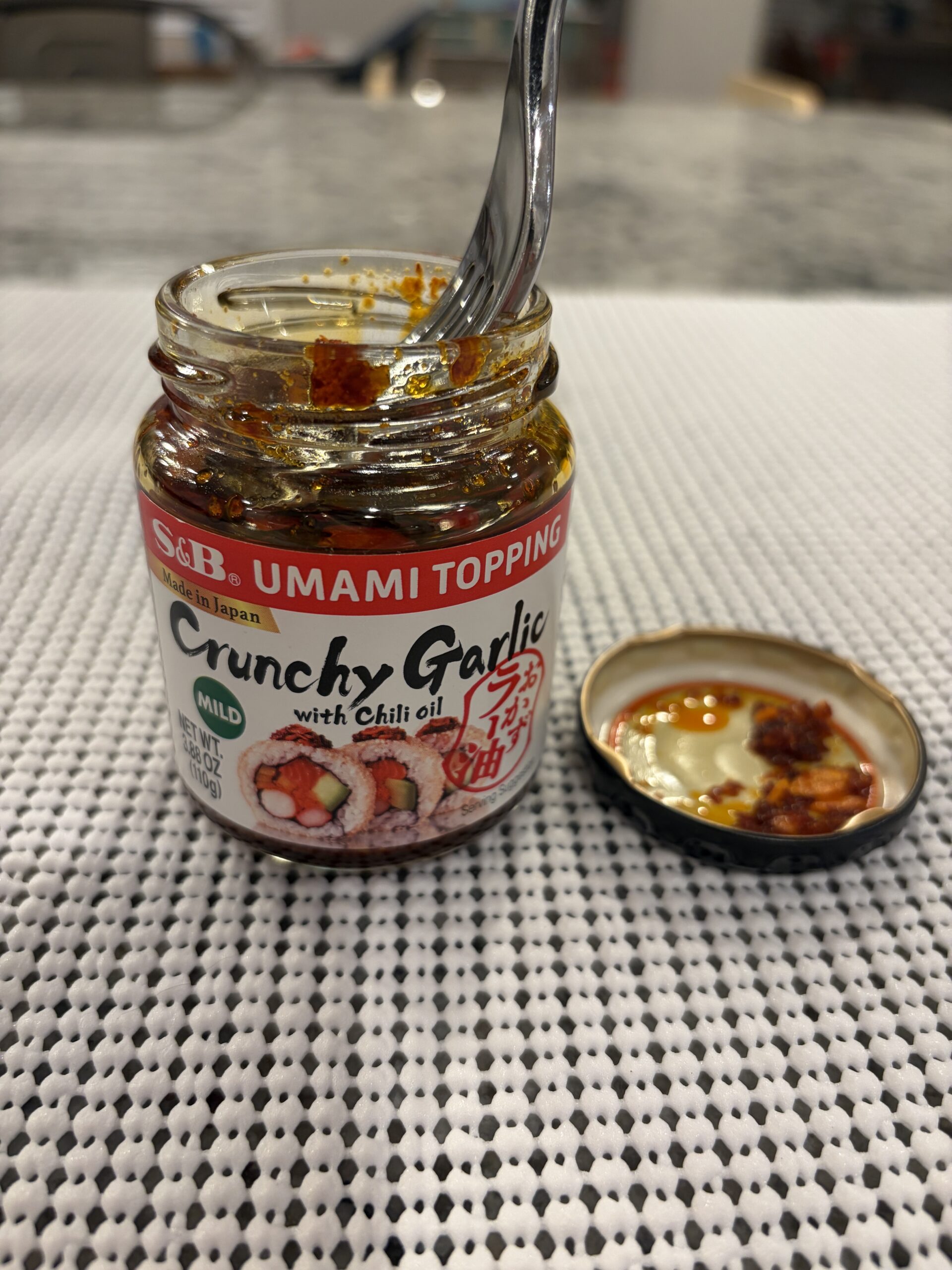 S&B Crunchy Garlic chili crisp fork resting on dense crispy bits — Flavor Index Lab
