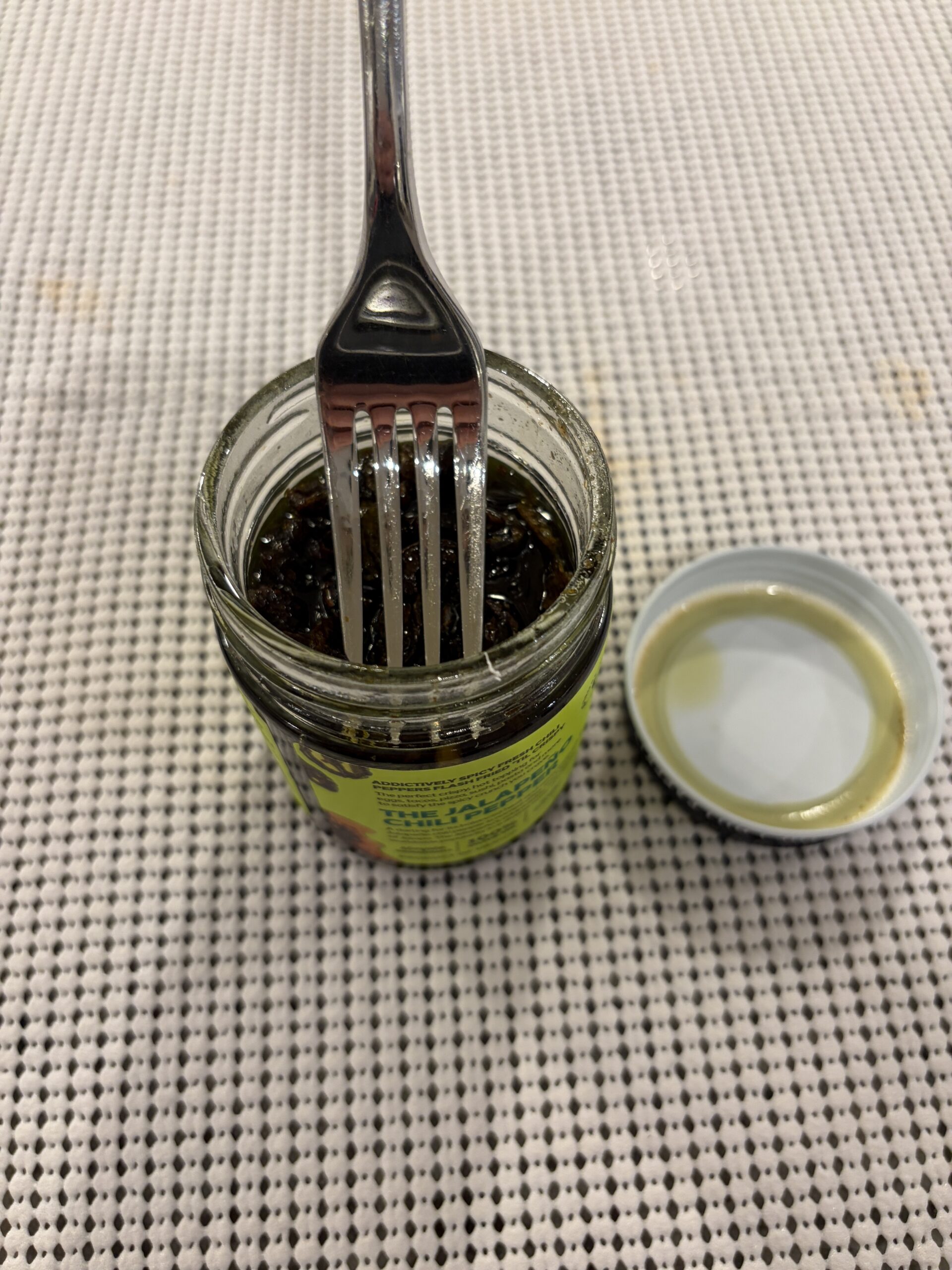 Fork resting on Don Chilio jalapeño chili crisp solids without sinking — Flavor Index Lab