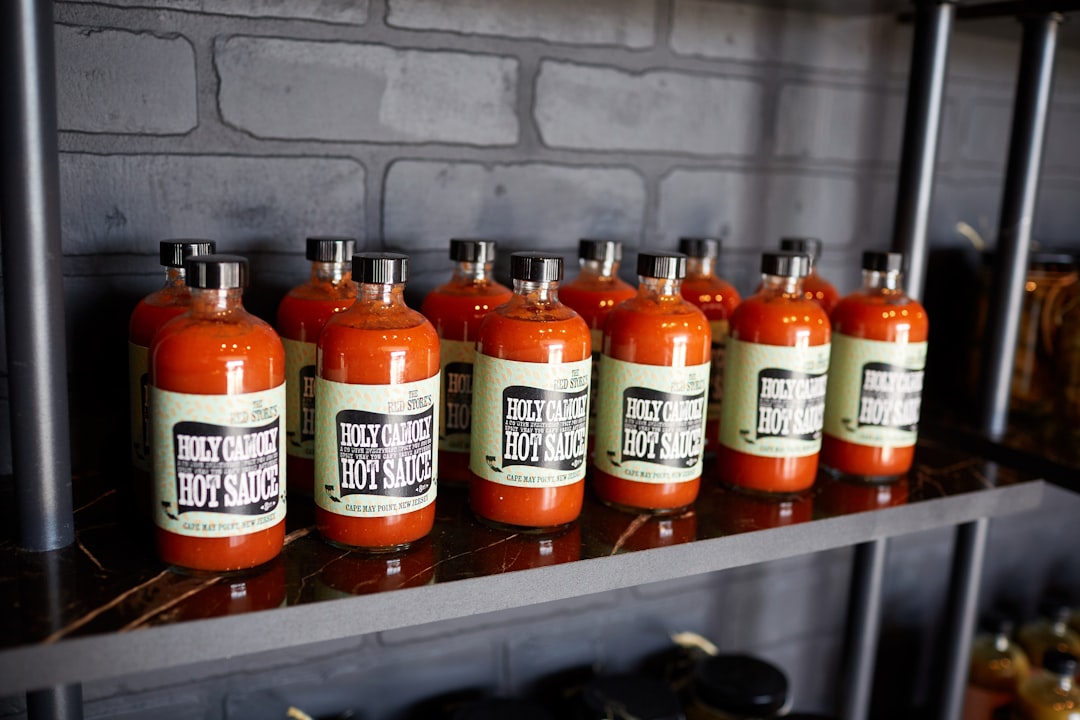 Collection of hot sauce bottles on a shelf — Flavor Index Lab