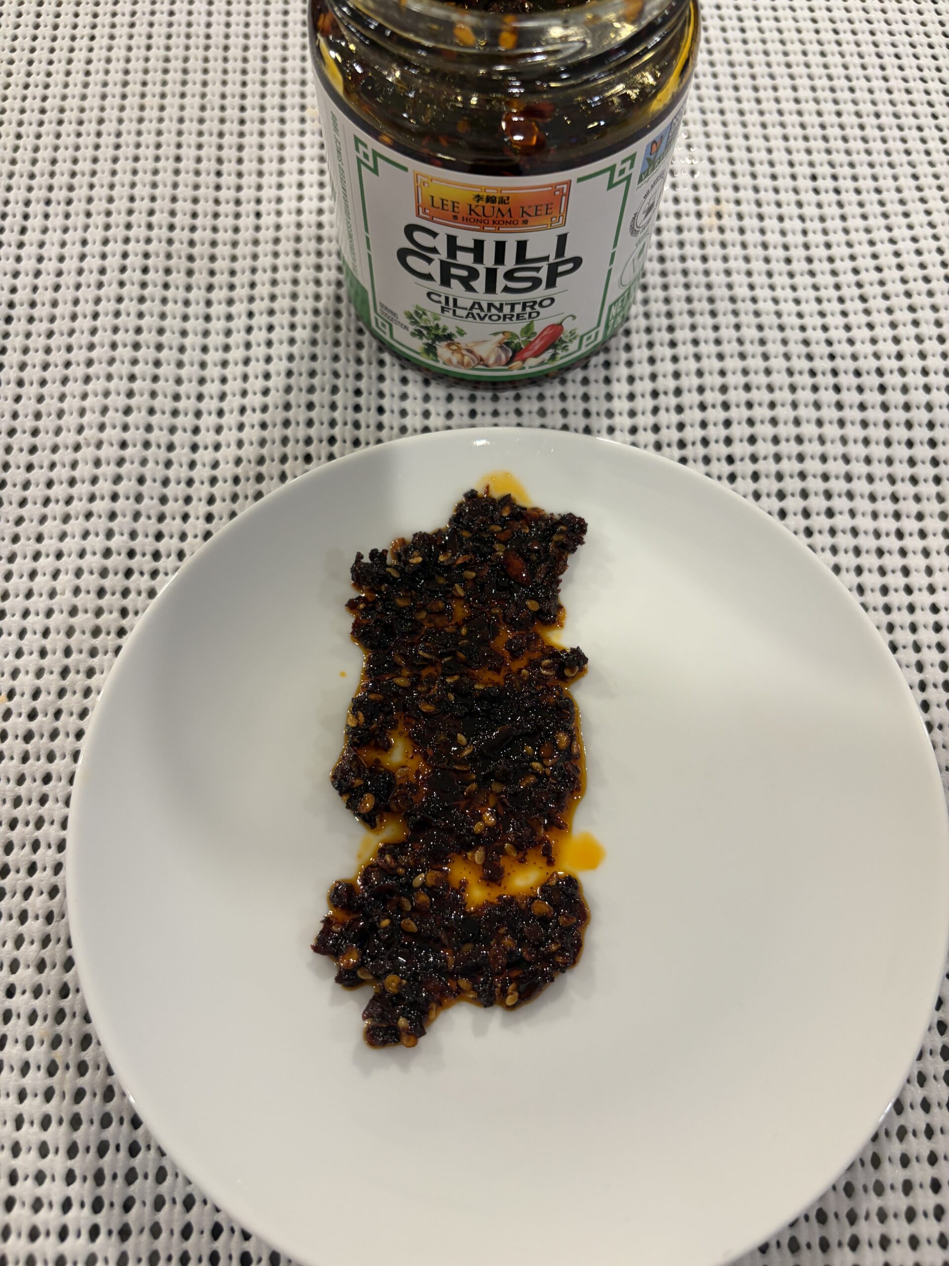 Lee Kum Kee cilantro chili crisp spread on white plate — Flavor Index Lab