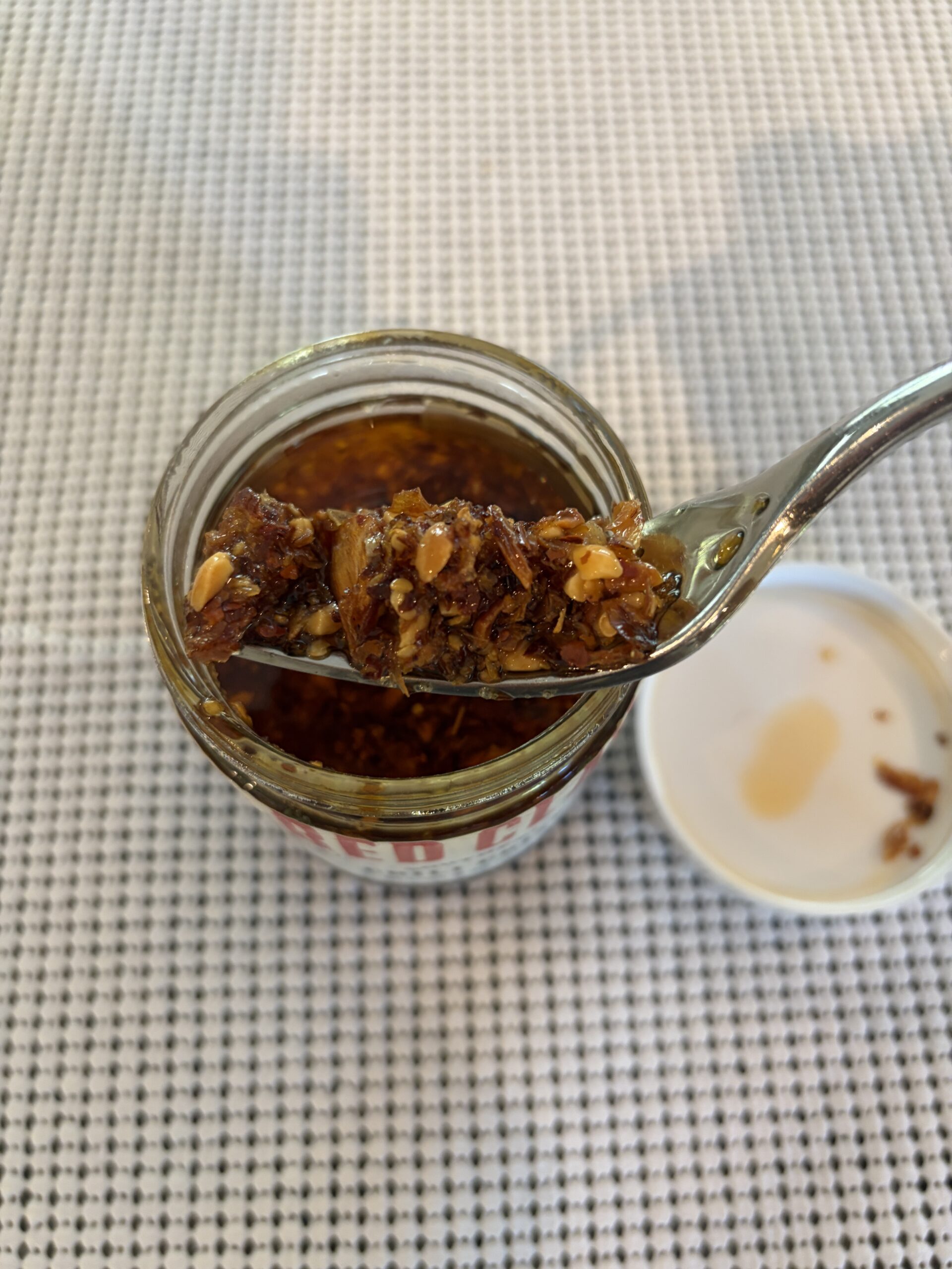 Red Clay chili crisp fork pull showing peanut and chili bits — Flavor Index Lab