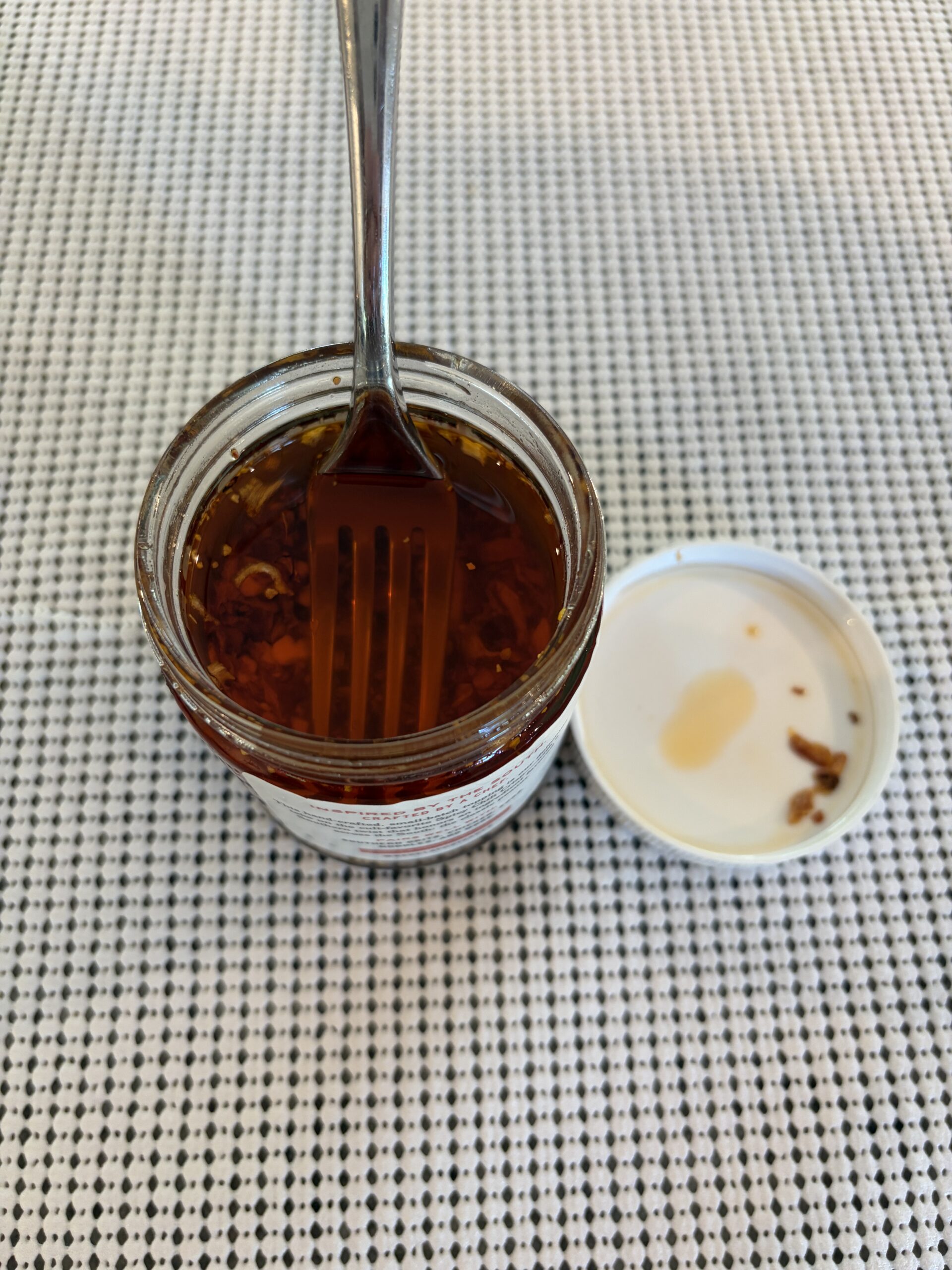 Fork resting on Red Clay chili crisp solids before stirring — Flavor Index Lab