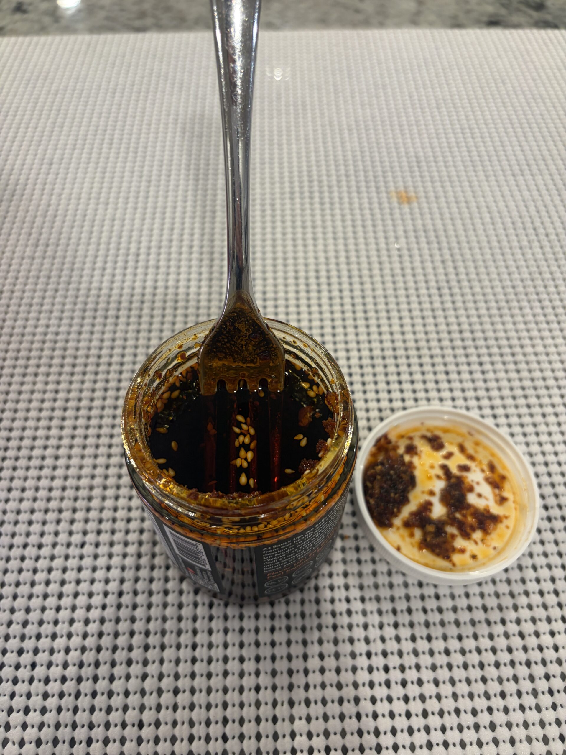 Fork resting on Sauce Up Extra Spicy chili crisp solids — Flavor Index Lab