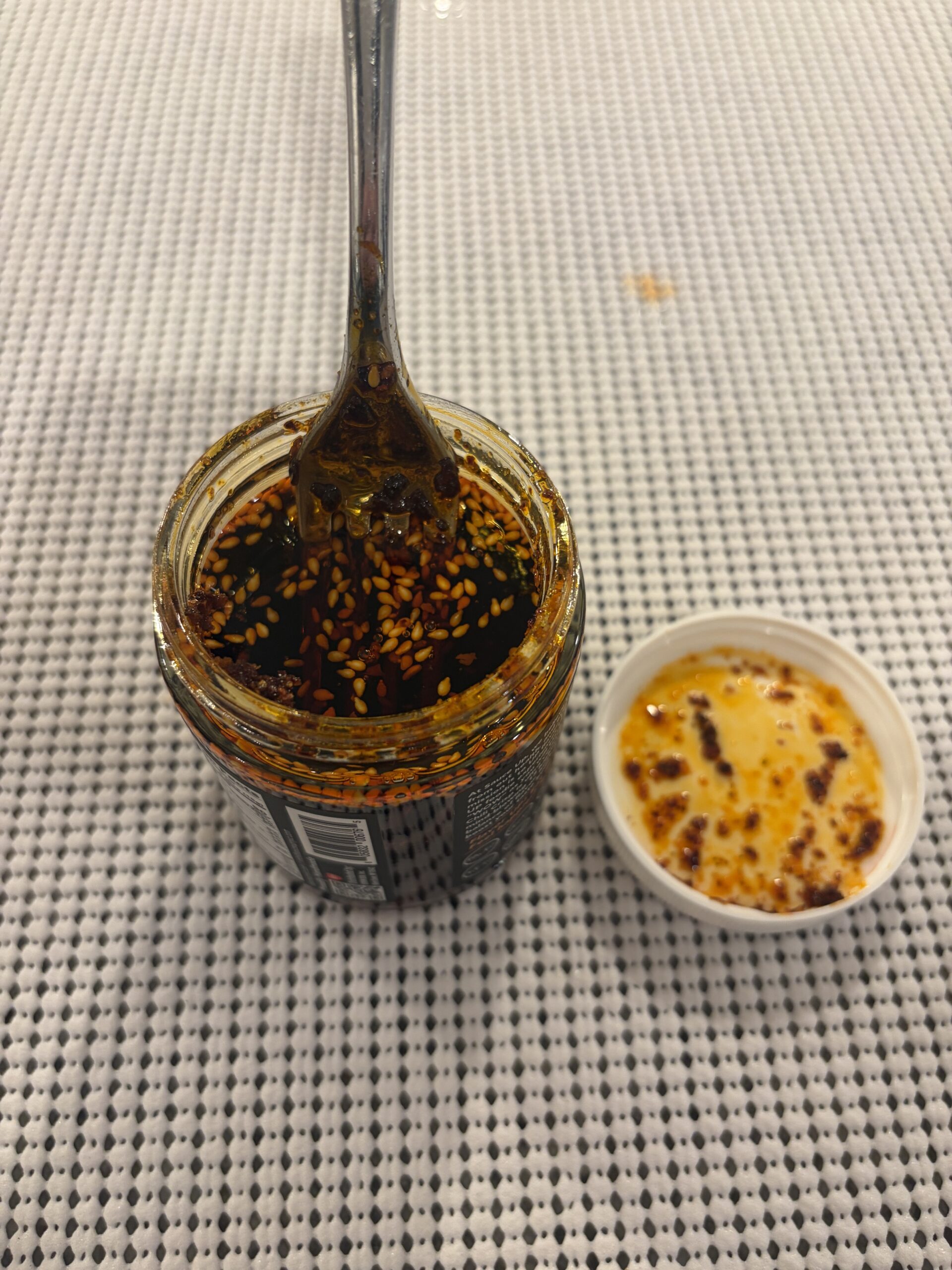 Fork resting on Sauce Up chili crisp solids before stirring — Flavor Index Lab