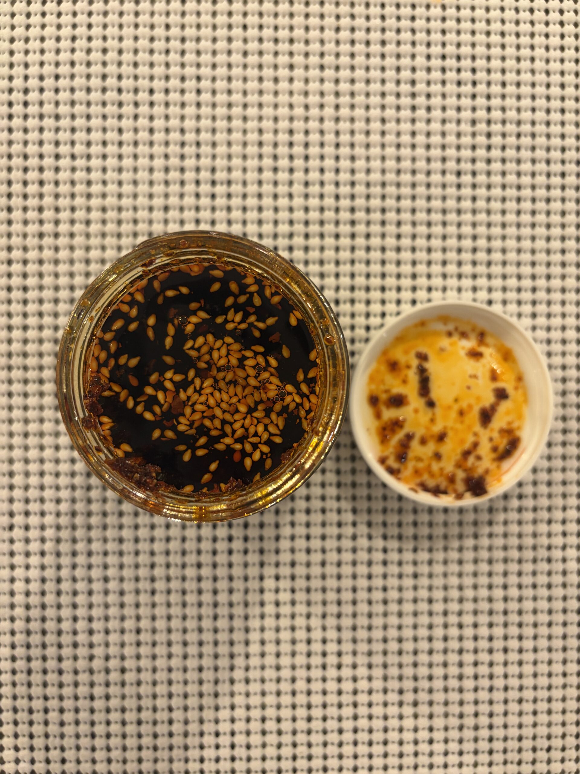 Sauce Up chili crisp open jar showing deep red sauce and sesame seeds — Flavor Index Lab