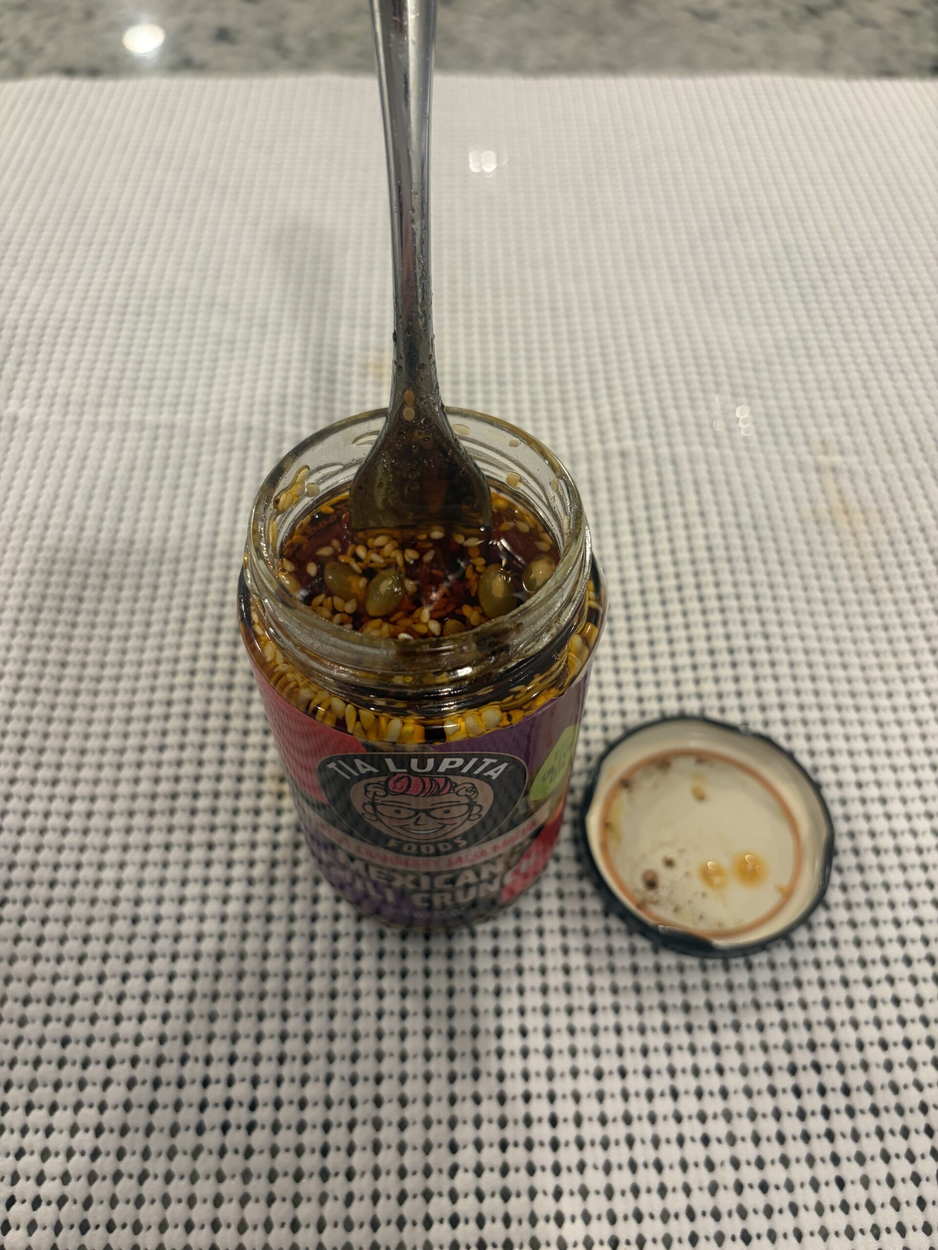 Fork resting on Tia Lupita Sweet Cranberry salsa macha solids . Flavor Index Lab