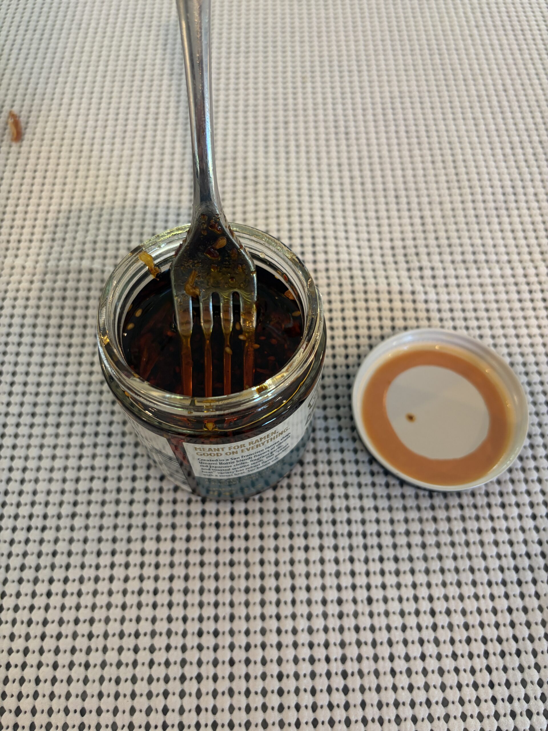 Fork resting on Umami Hottie chili oil solids without sinking — Flavor Index Lab