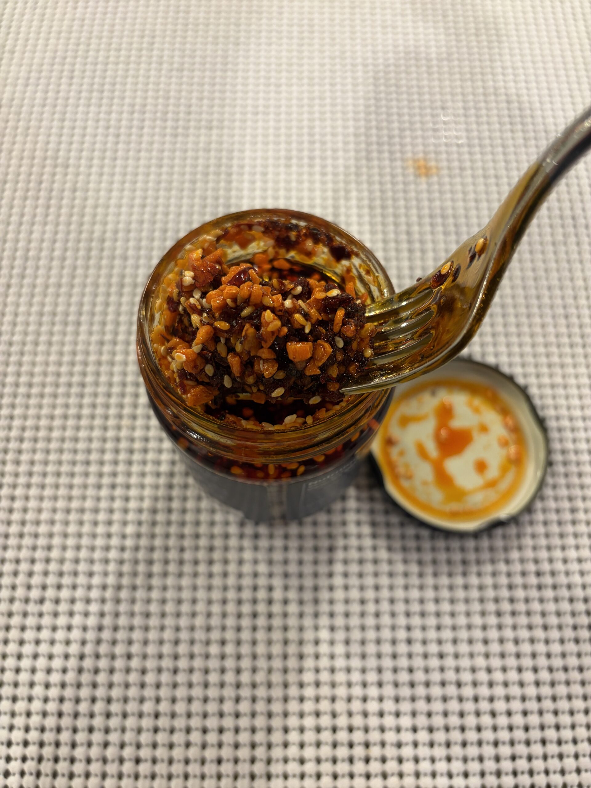 WUJU Sweet Heat chili crisp fork pull showing texture and oil cling — Flavor Index Lab