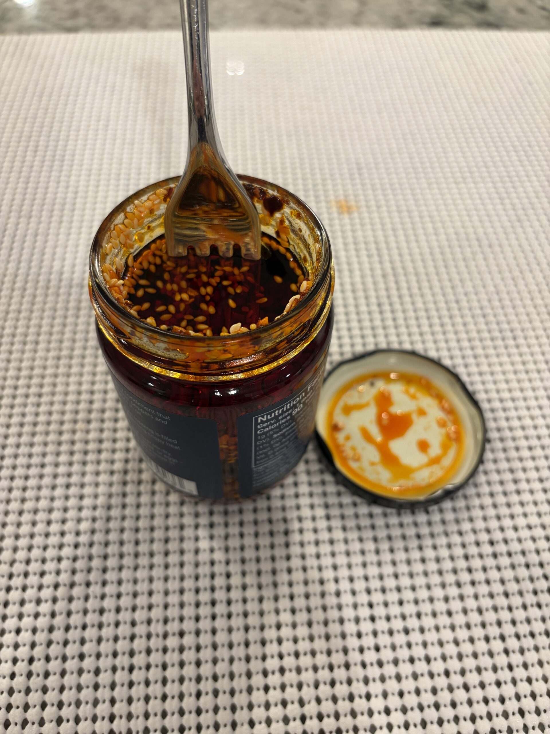 Fork resting on WUJU Sweet Heat chili crisp solids before stirring — Flavor Index Lab