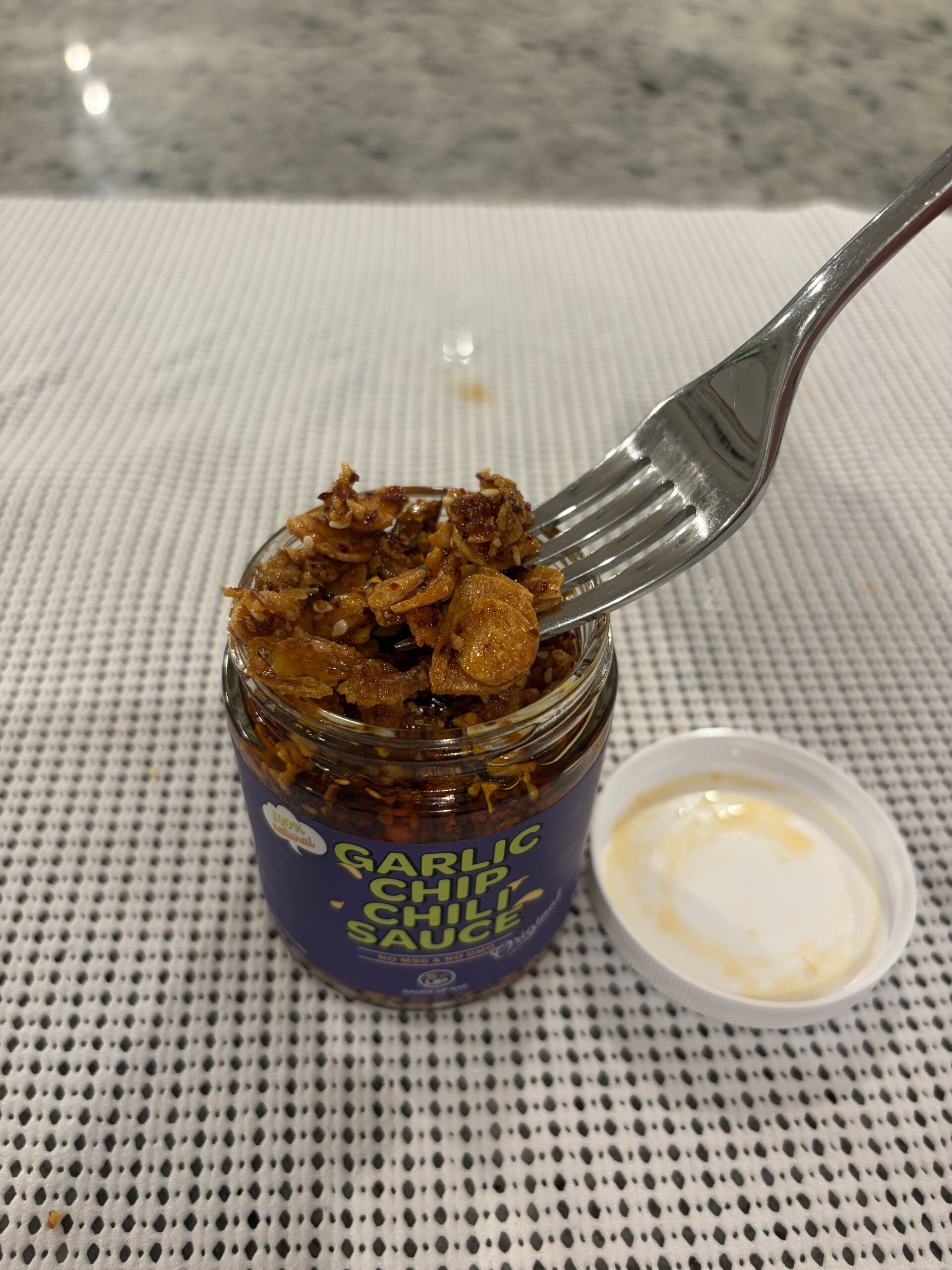 Sauce Up NYC garlic chip chili sauce fork pull showing chunky texture — Flavor Index Lab