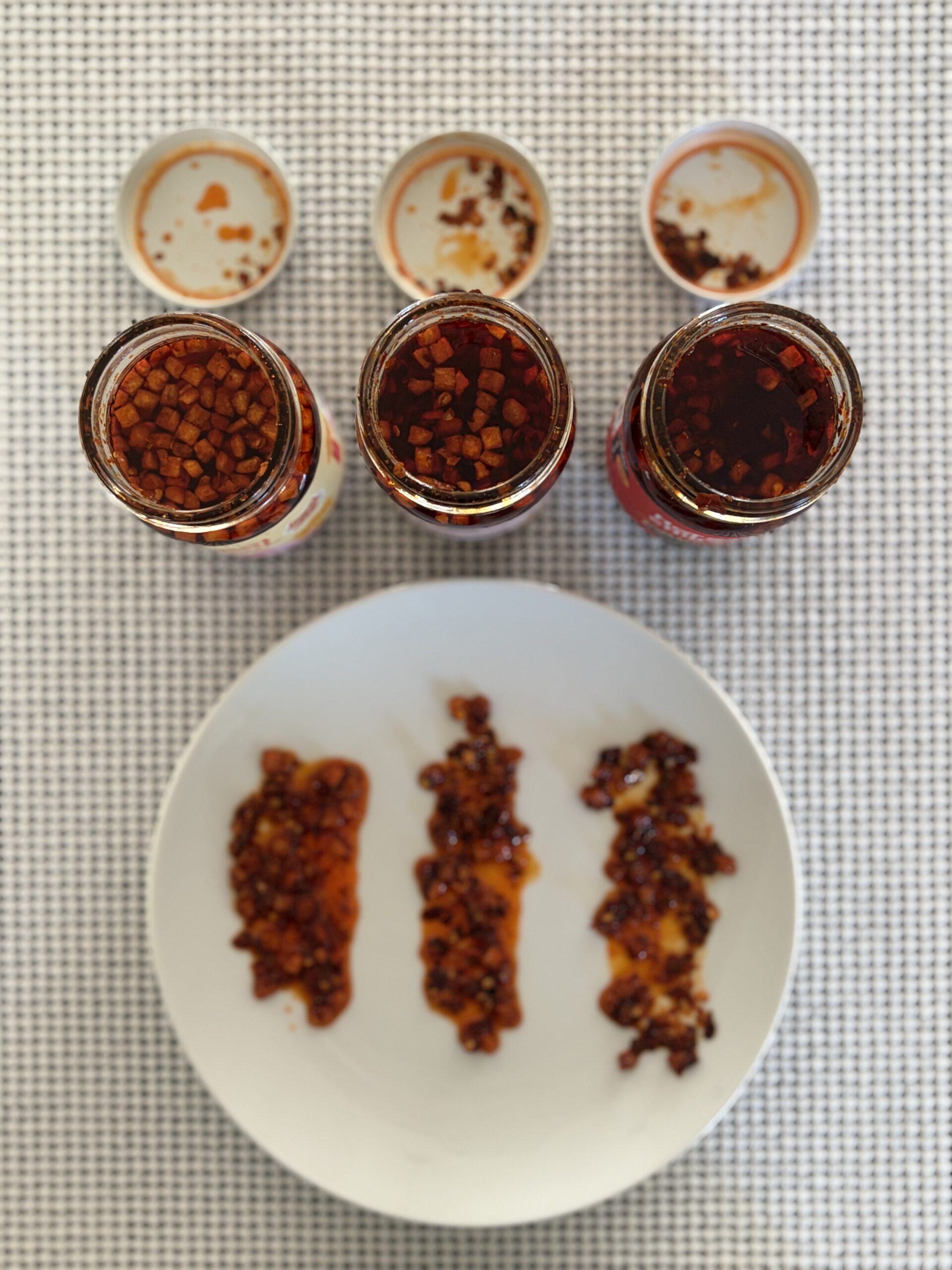 Hot Boi Chili Oil Mild, OG, and Fire spread on a white plate, top-down — Flavor Index Lab