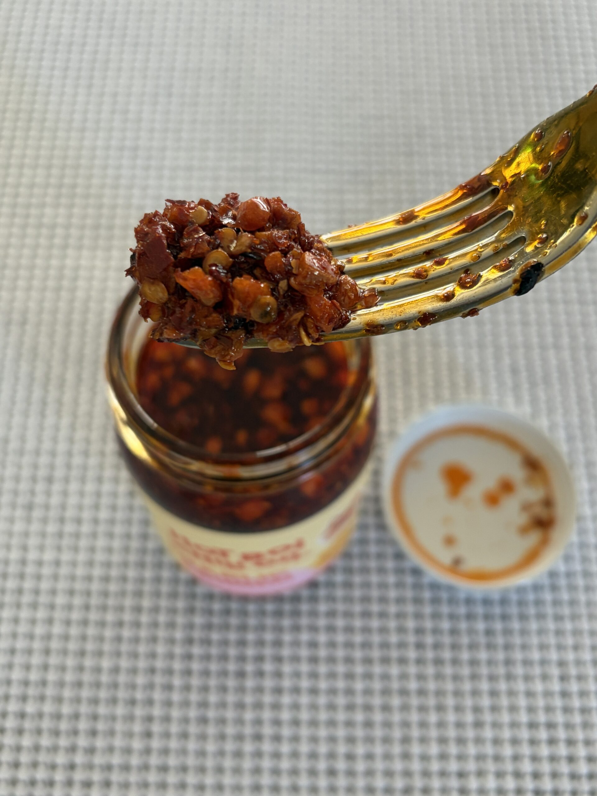 Hot Boi Chili Oil Mild fork pull showing garlic chunks and oil — Flavor Index Lab