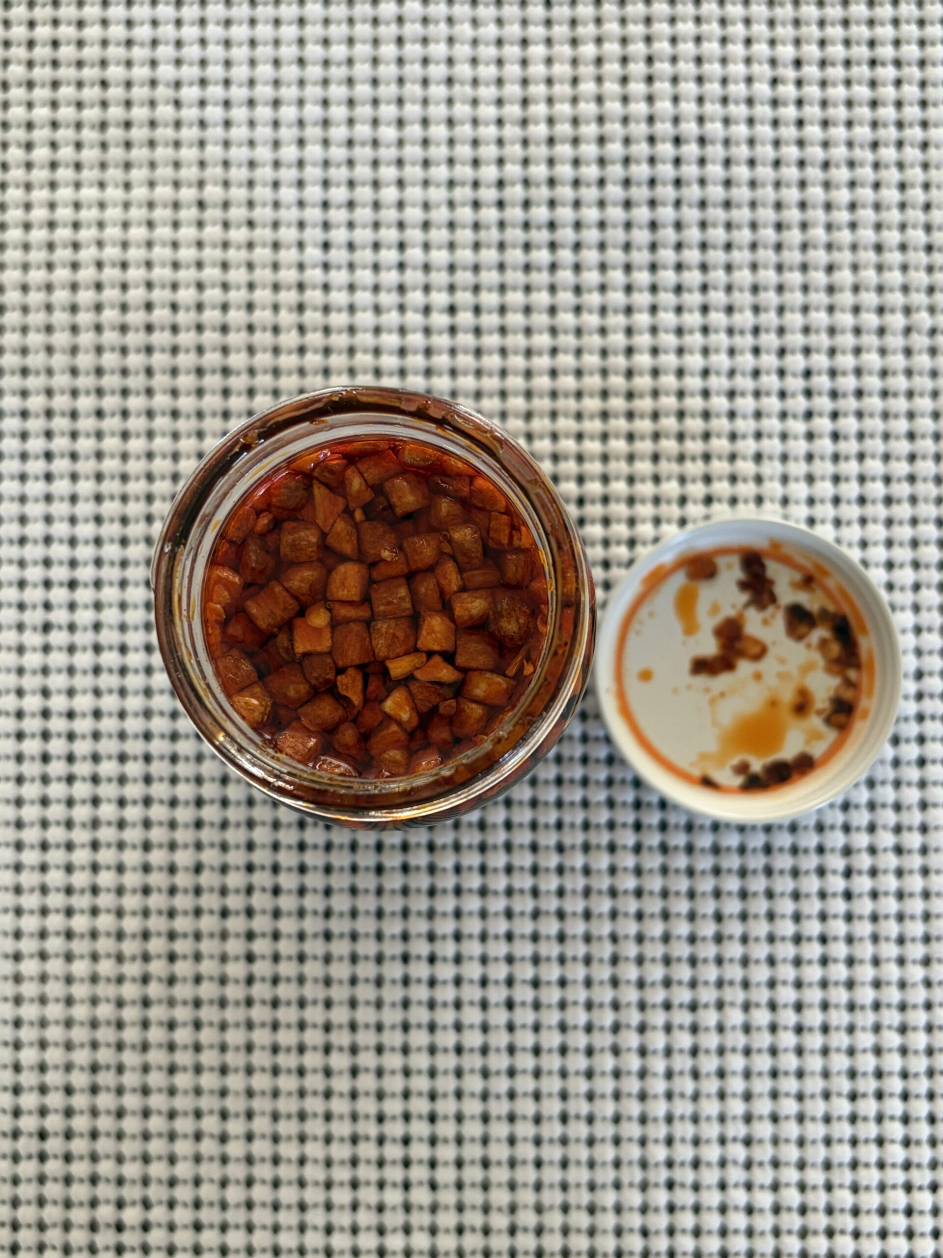 Hot Boi Chili Oil OG open jar with garlic chunks floating on top — Flavor Index Lab